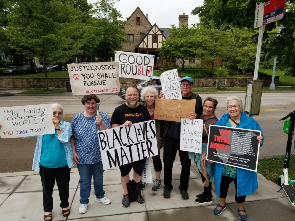 Fabrangeners with protest signs outdoors during the 16th Street protests.