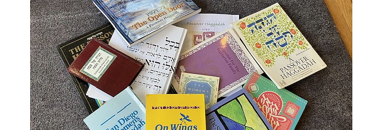 Collection of haggadot spread on a table